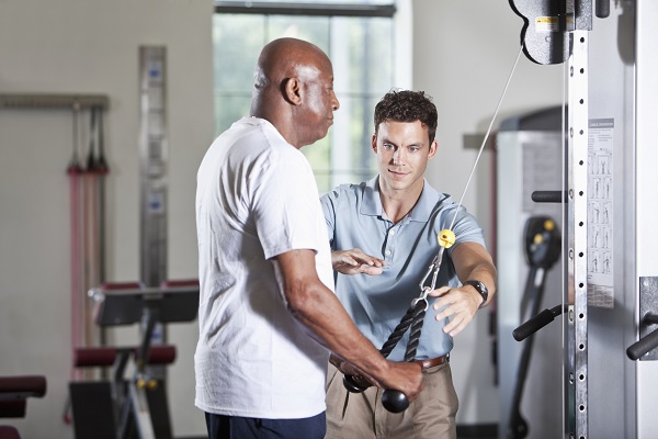 Physical therapist helping African American patient Physical therapist helping African American patient