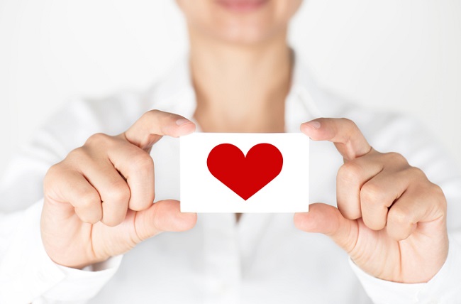 Showing Heart Person holding out a card with a red heart