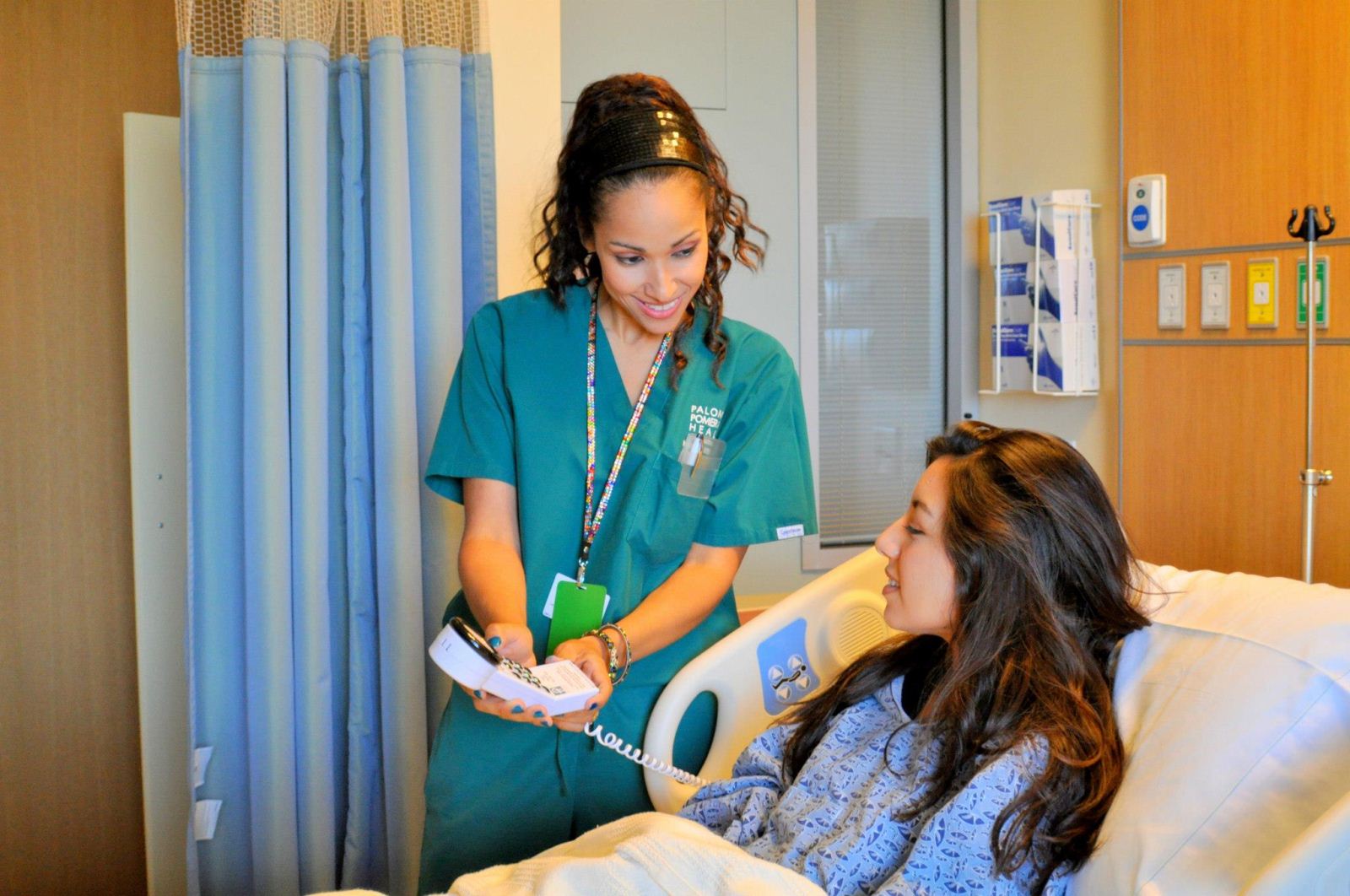 Female nurse helping female patient